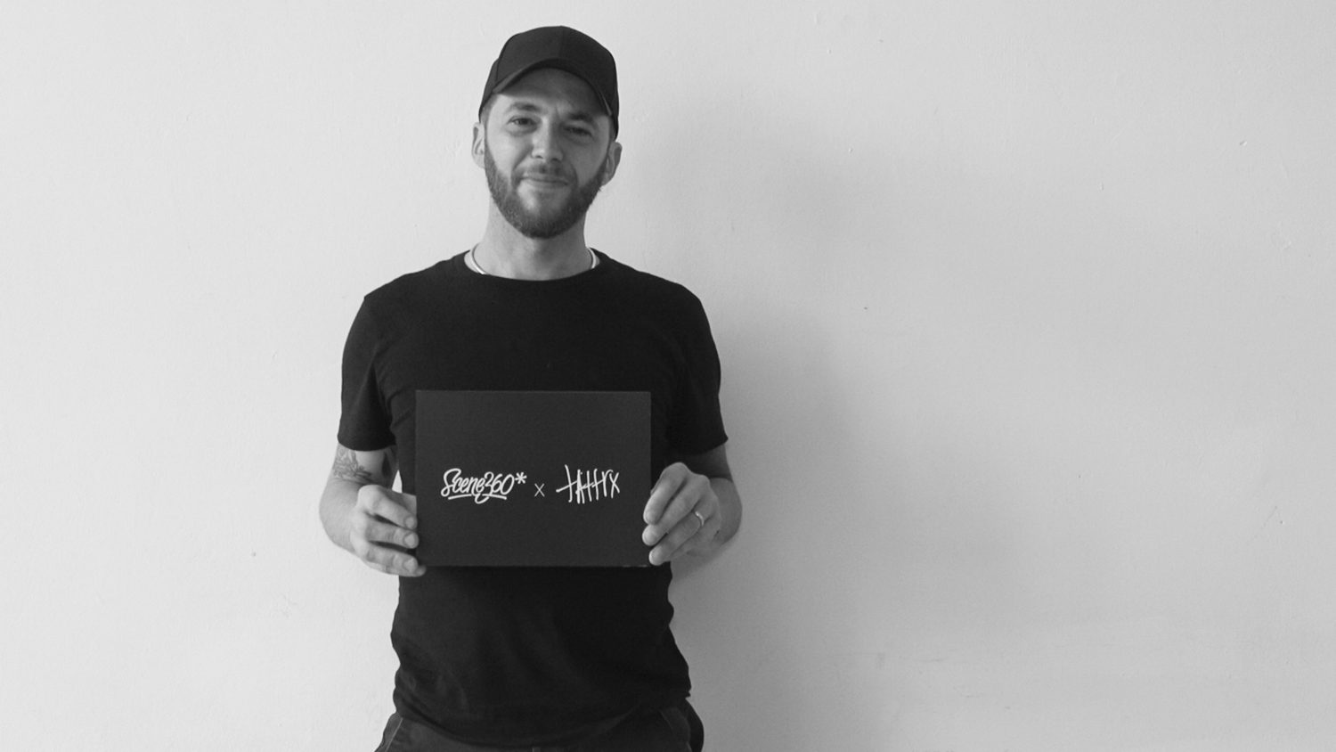 otto d'ambra tattooer holding sign: scene360 x tattrx