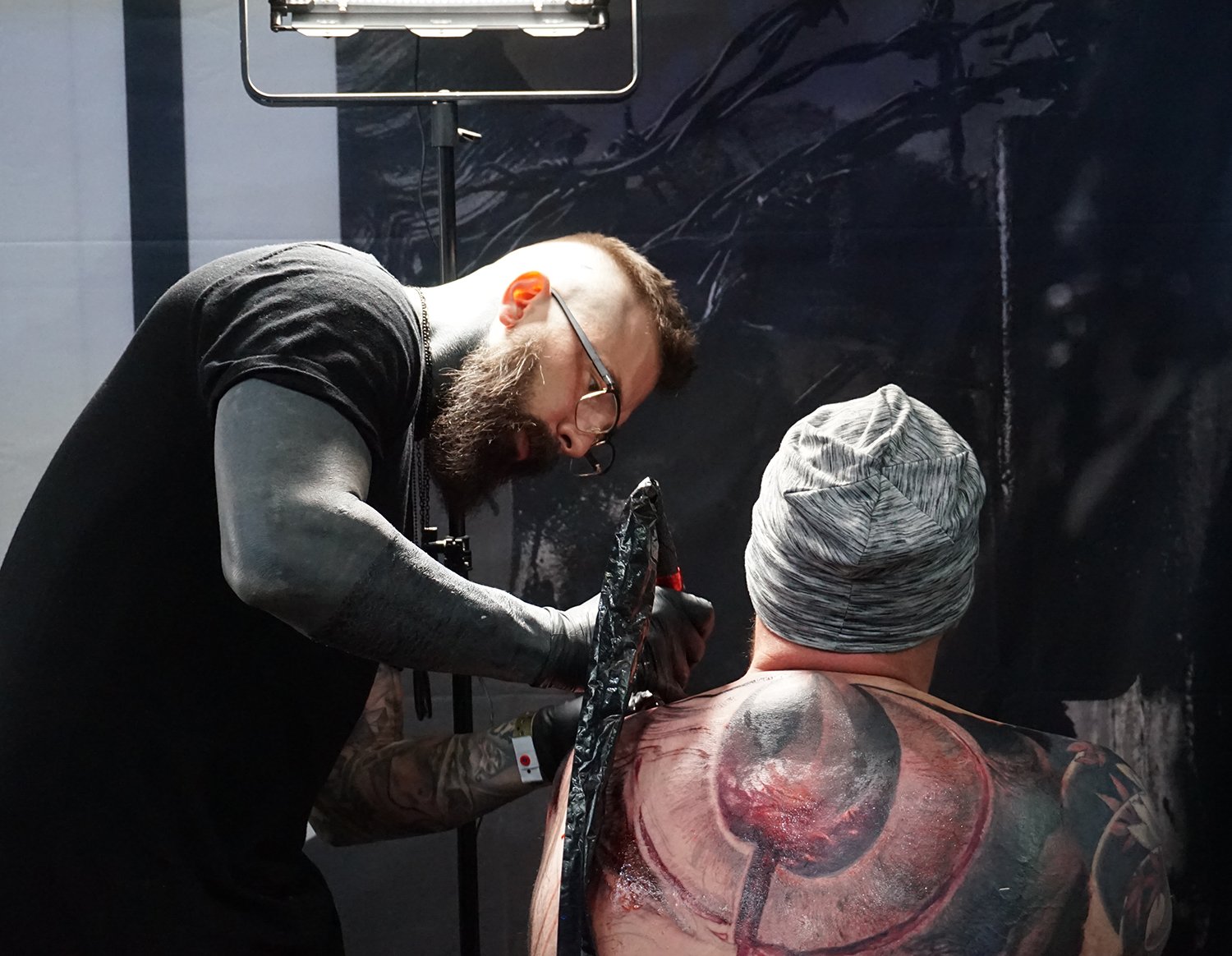 kamil mocet tattooing back piece at event