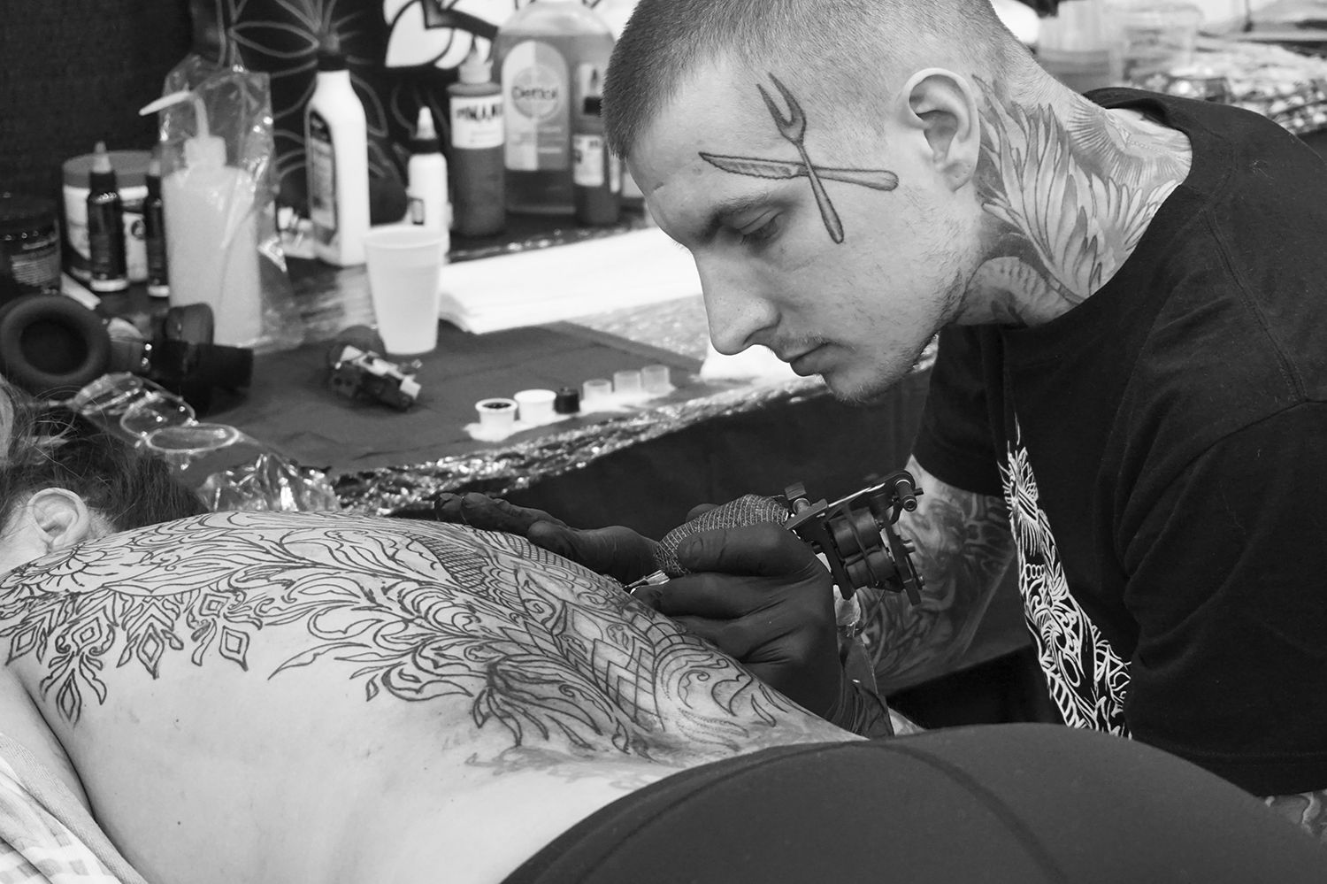 tom maggot working on ornamental back tattoo , pasadena