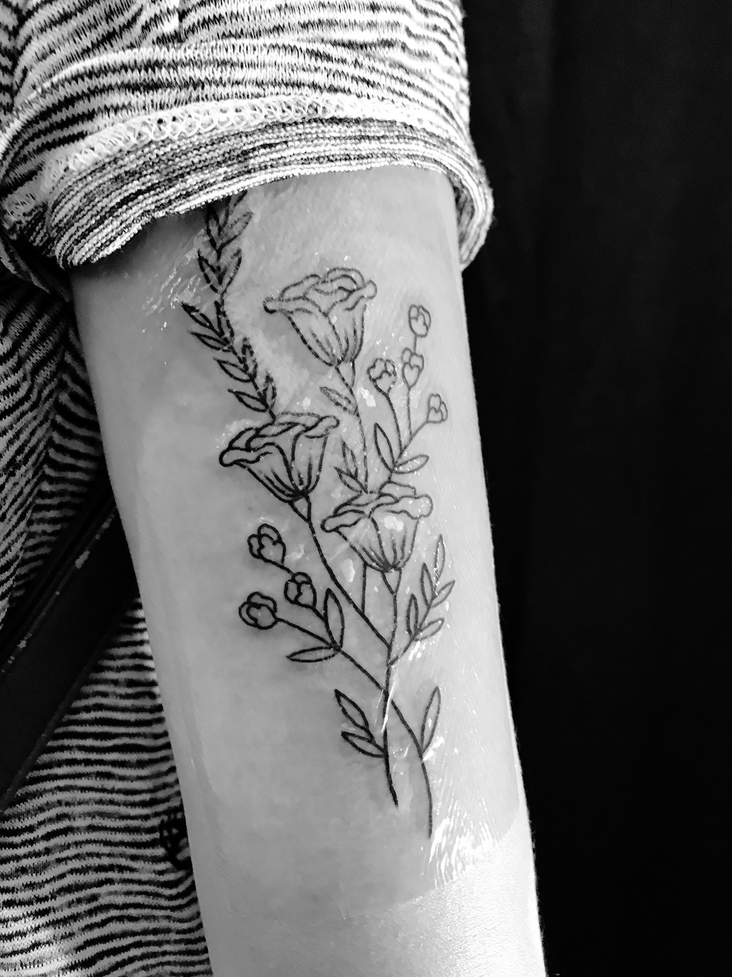 floral blackwork by Rose & Thorn Tattoo, san francisco, with saniderm on arm