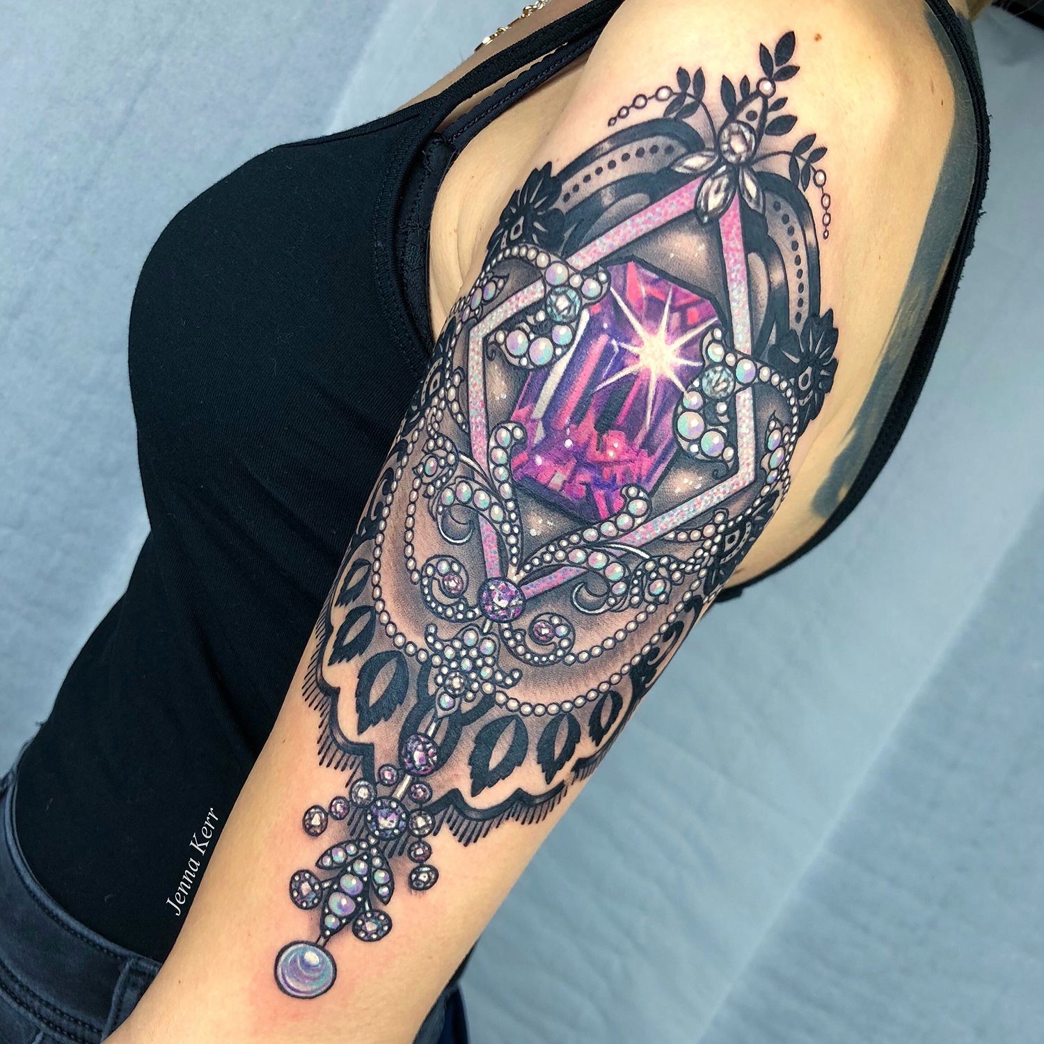pink and purple jewelry tattoo on arm
