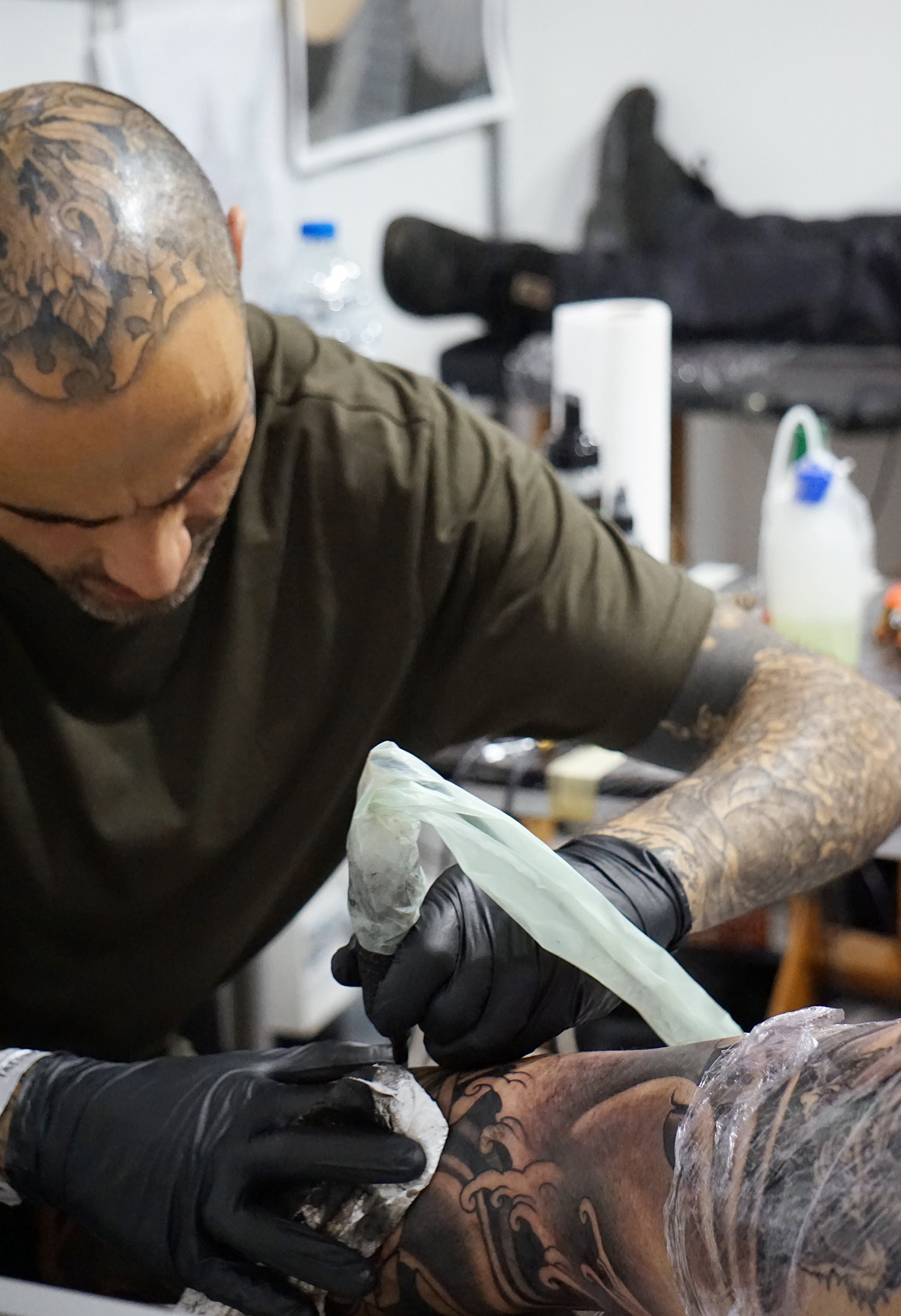 tattooer Alberto Solposto adding a Tibetan skull on the bodysuit.