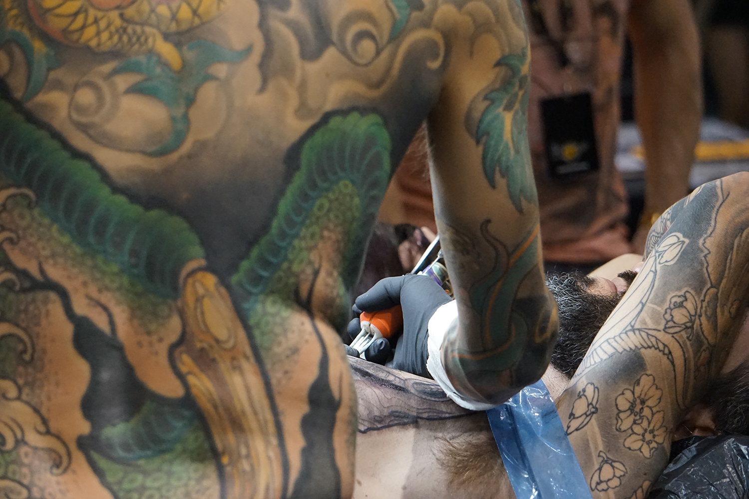 Tattooer Alexandre Abreu working on a large-chest piece. 