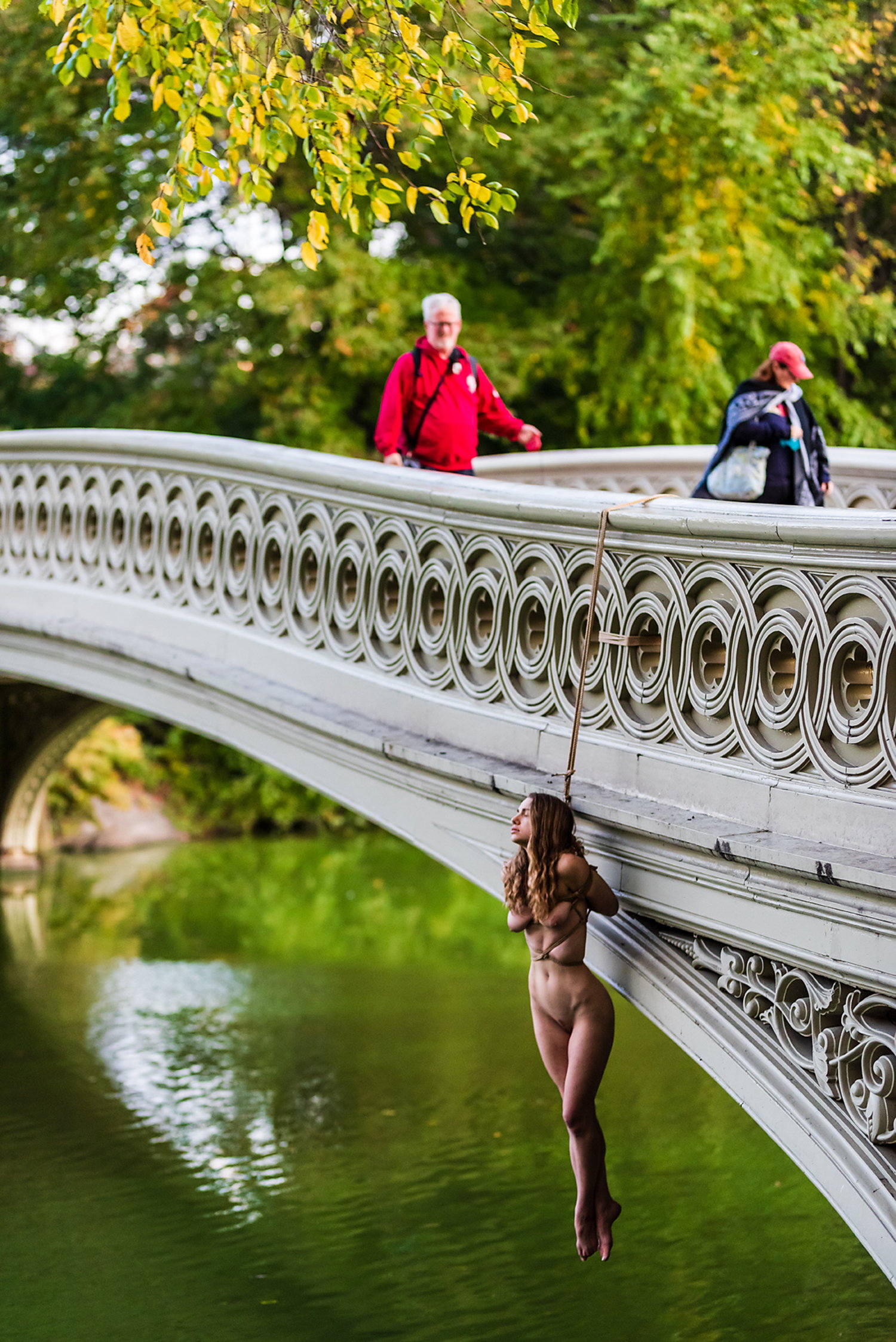 rope bondage, shibari, female model hanging on bridge - new york city