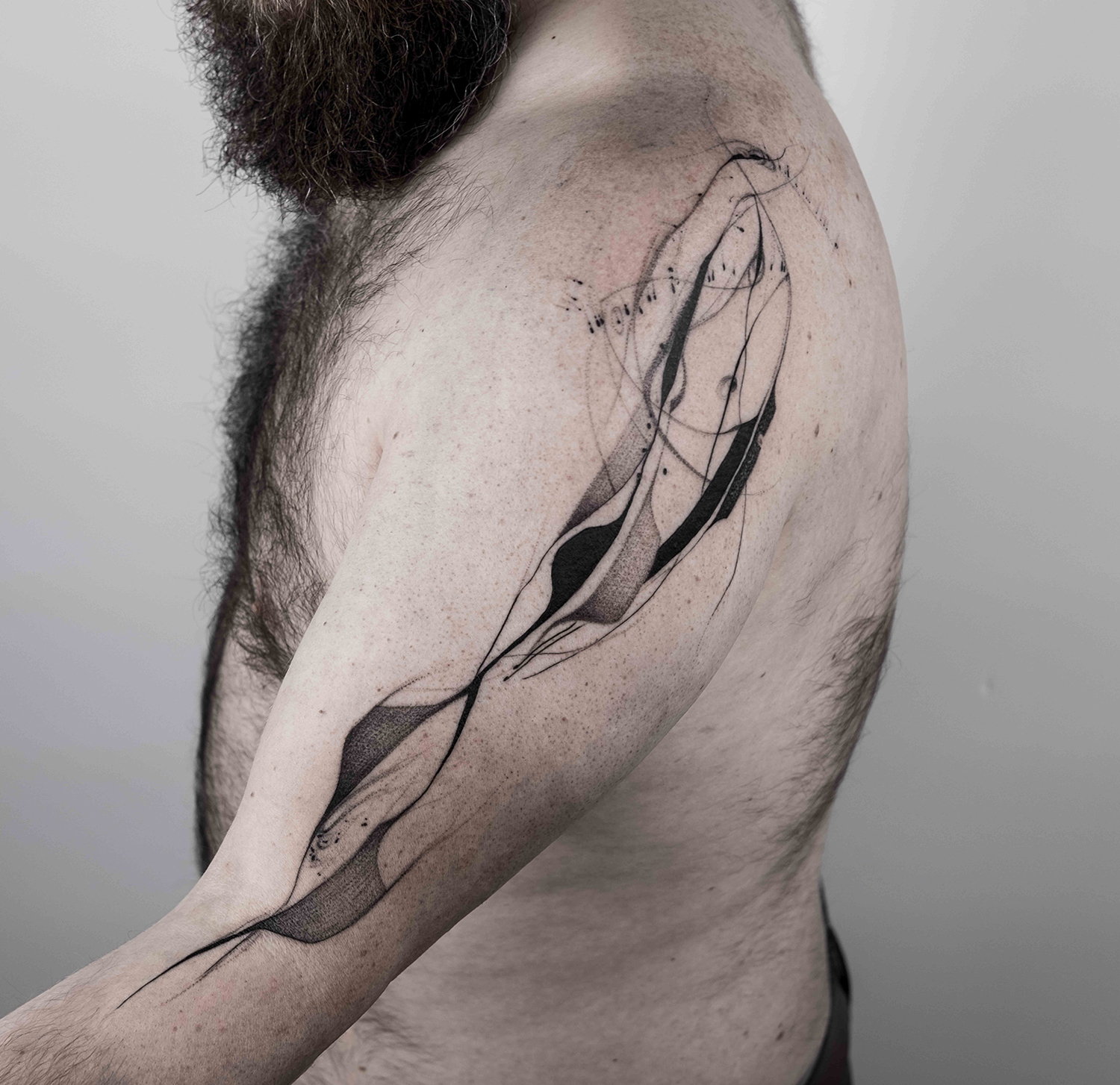 tatouage abstrait à l'encre noire sur le bras, à main levée