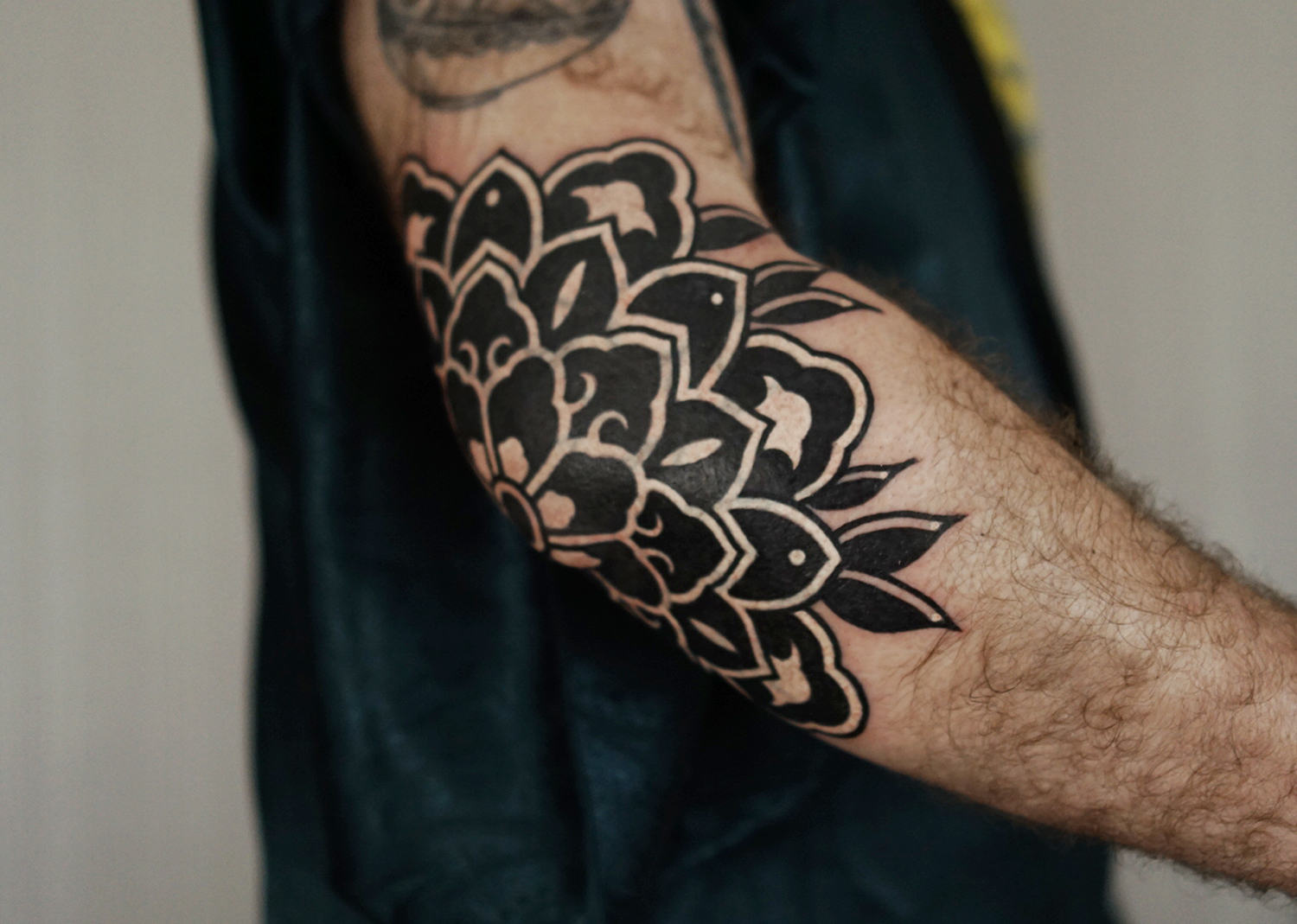 cover-up tattoo in black ink, mandala on elbow
