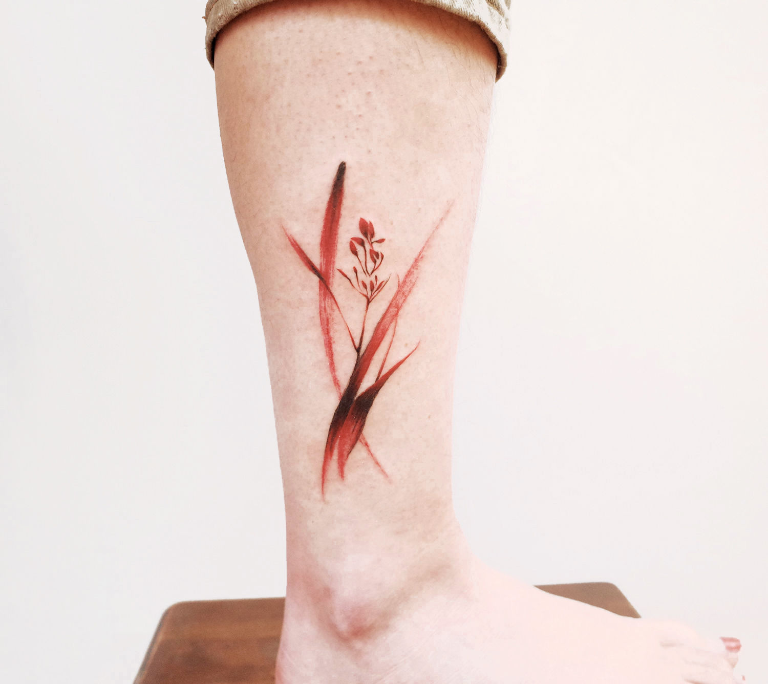 red plant tattoo, painting like on leg