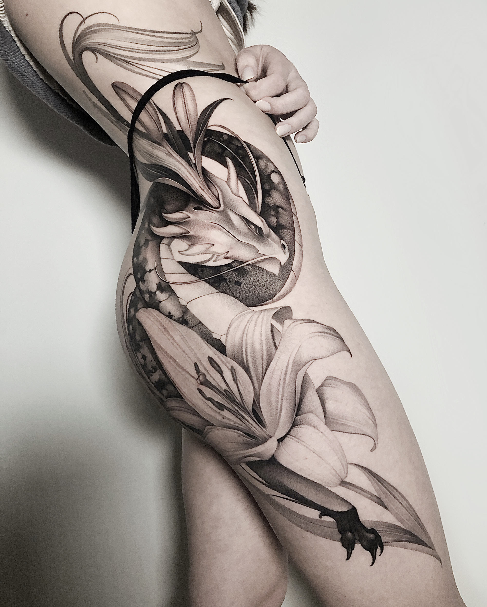 The dragon may symbolize power and change, while the lily may represent purity and innocence