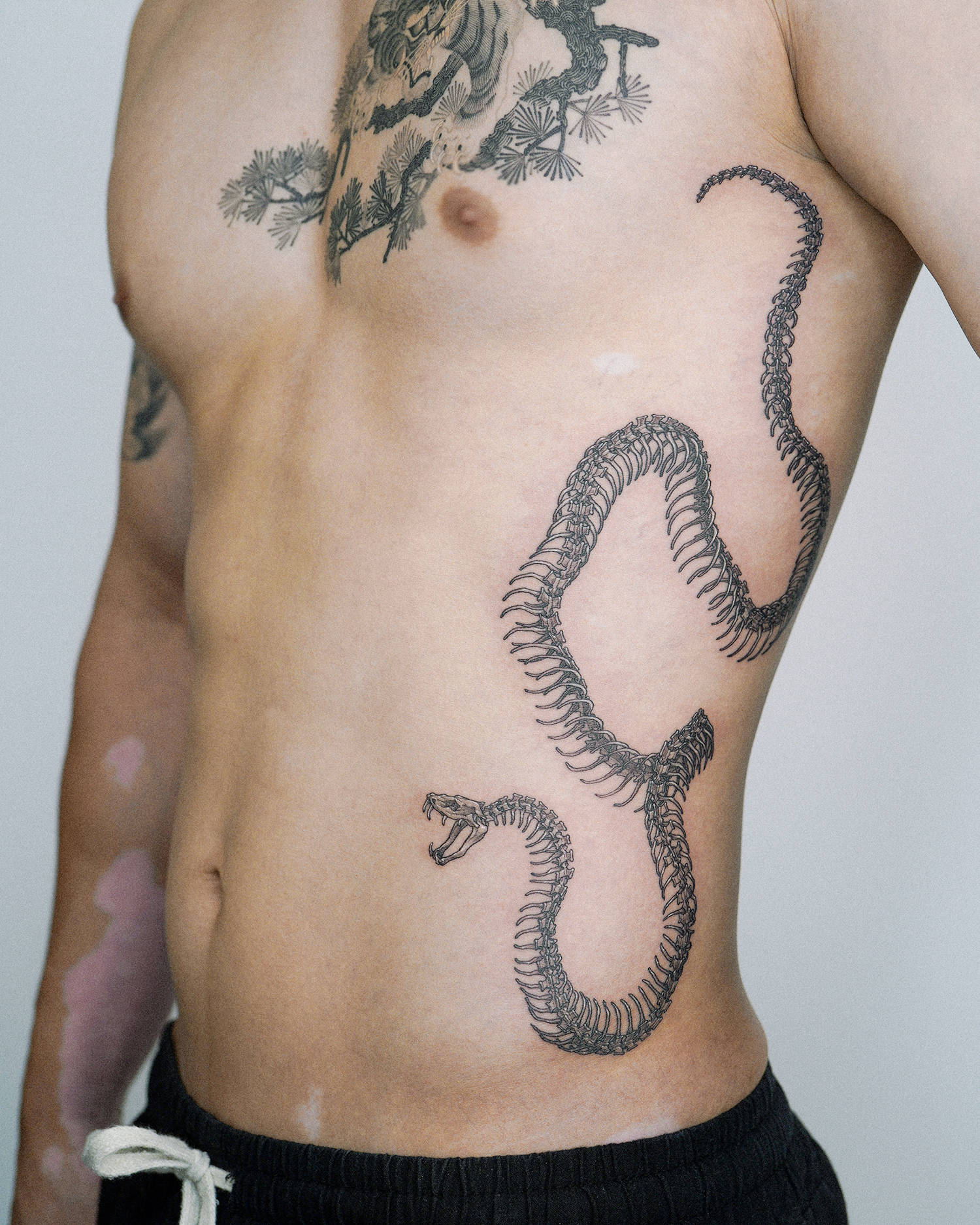 Fine line snake tattoo on the forearm