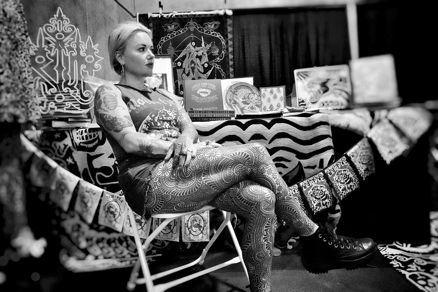 Taylor Bosworth, manager of Raking Light Gallery, with ornamental tattoos on her legs and hands by Guy Le