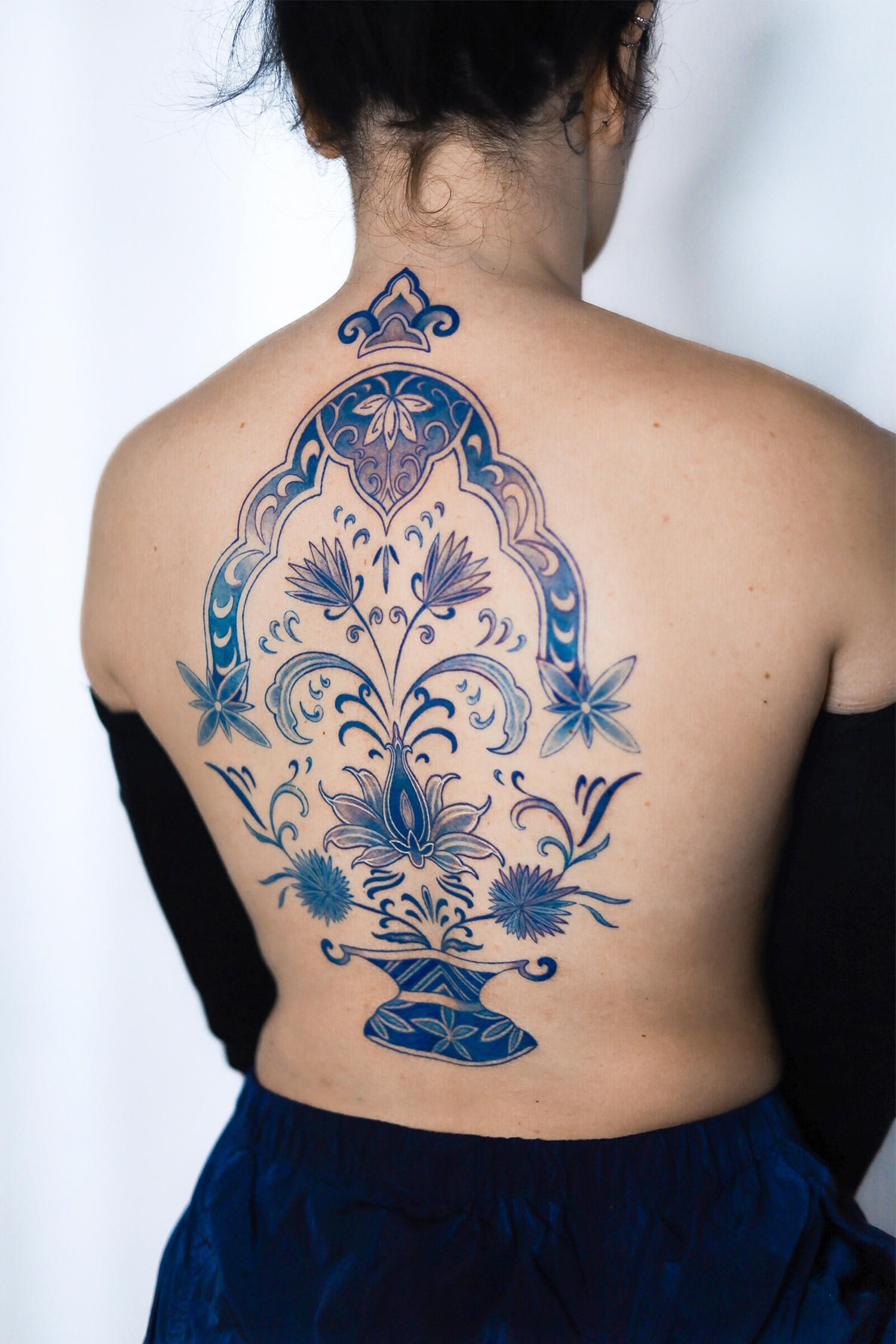 ornamental tattoo in blue ink on back, korean art