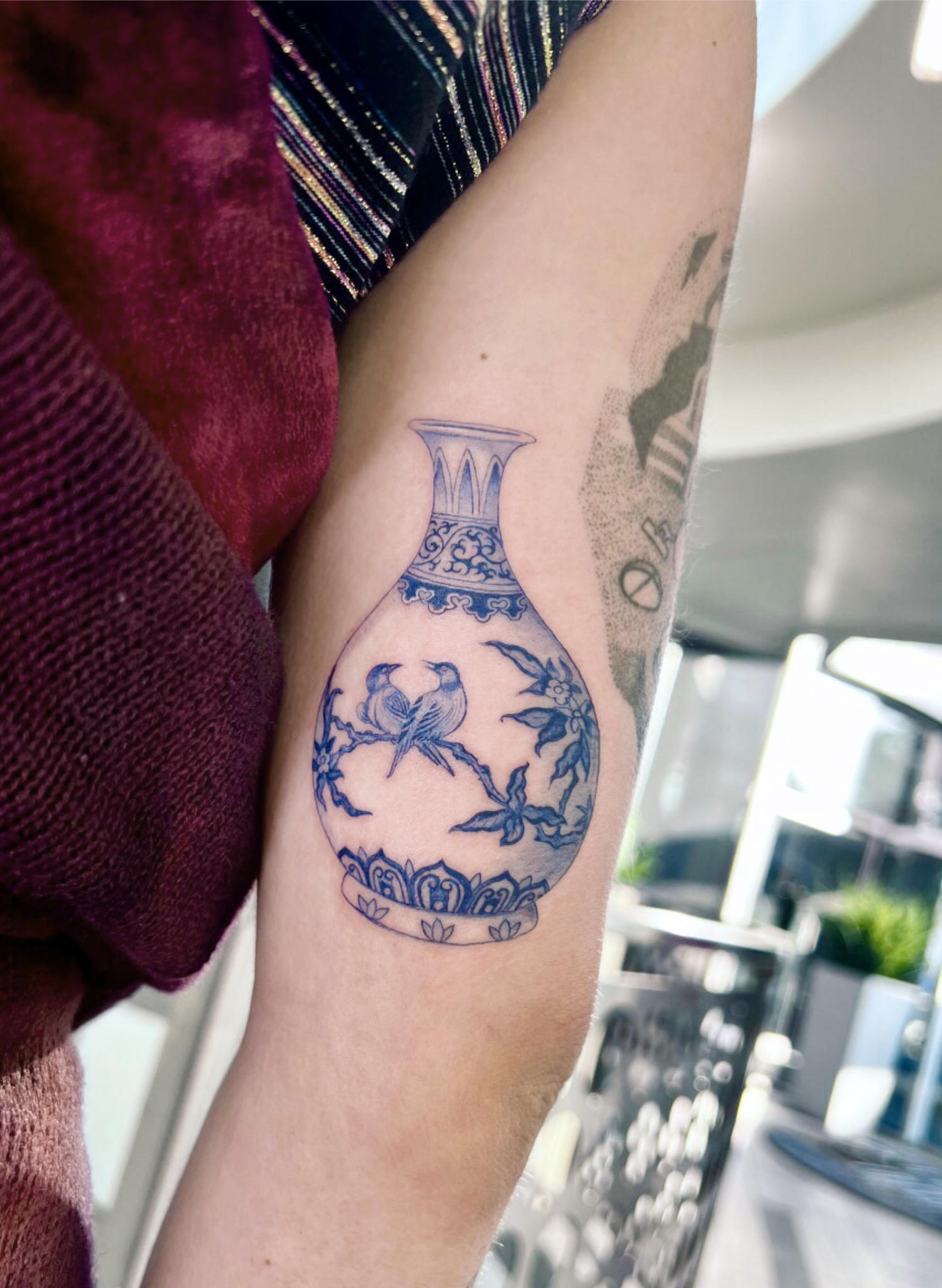 birds on vase tattoo on arm, blue ink