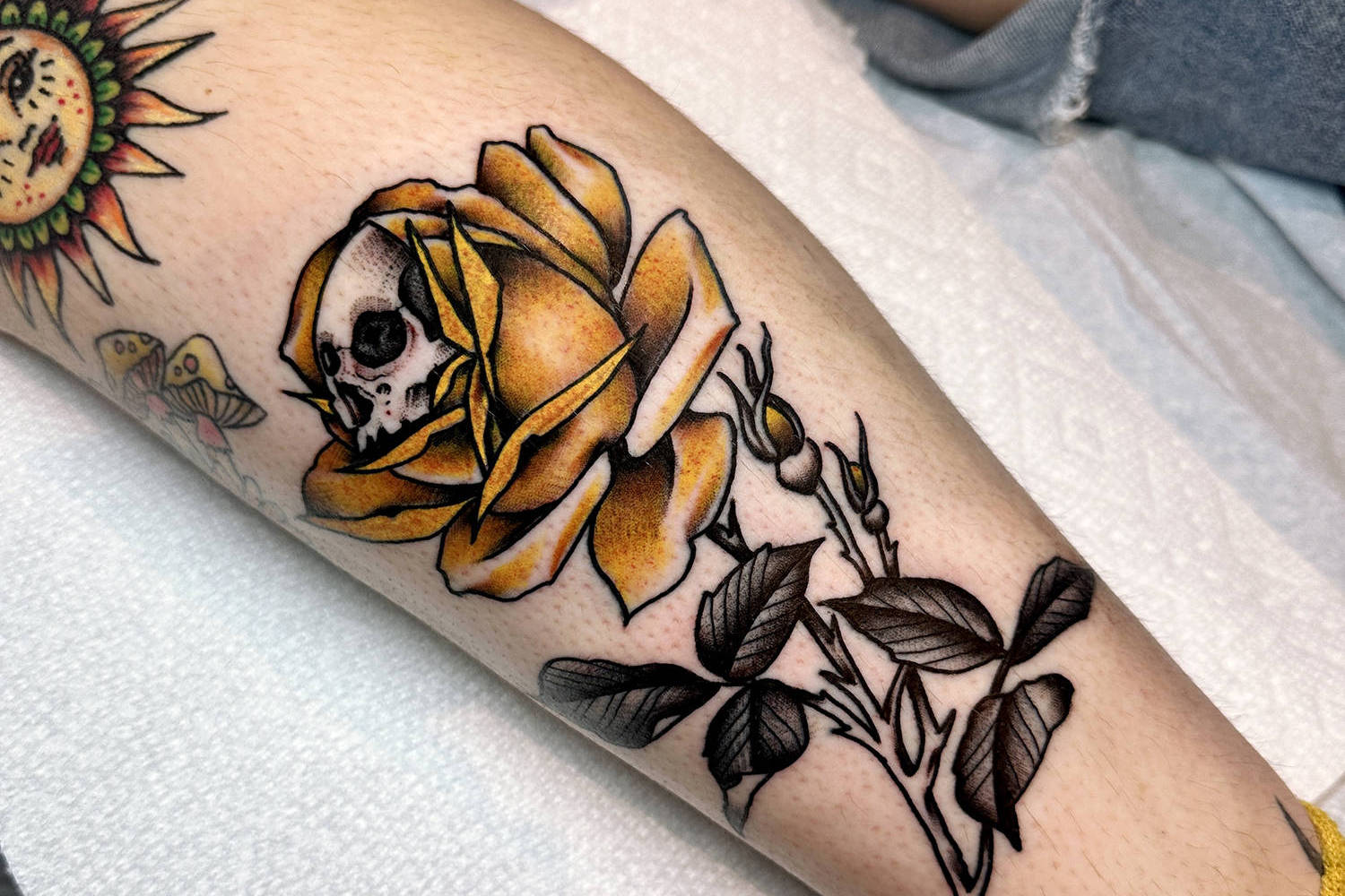 rose and skull tattoo on leg by mark clifford