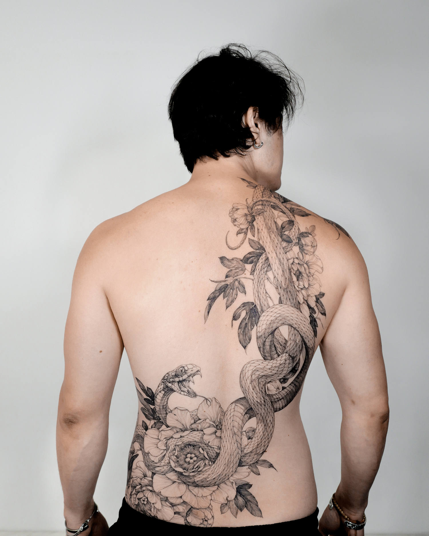 Snake and flower tattoo on back, fine line art