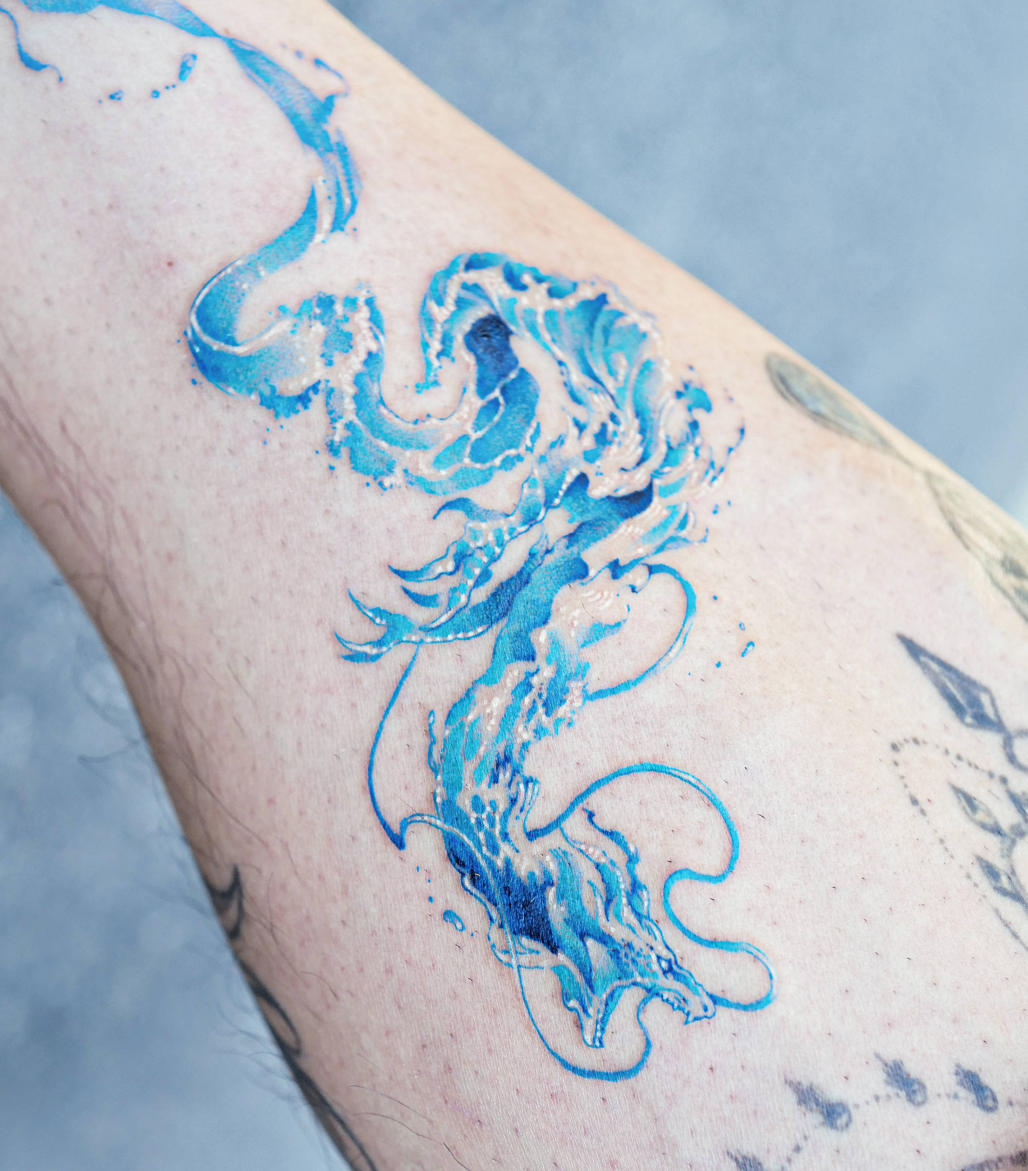 water textured dragon tattoo in blue ink