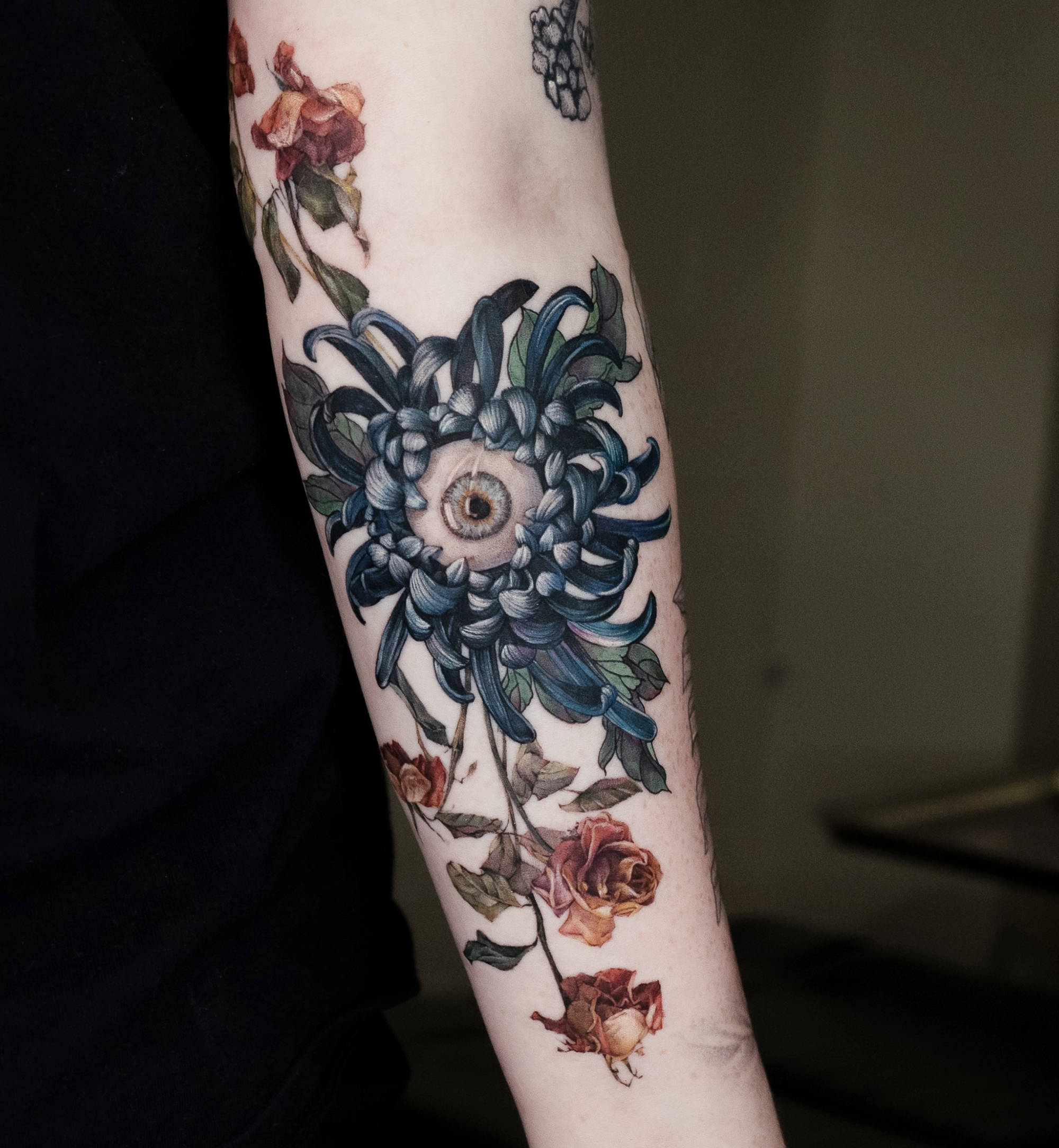 realistic eyeball tattoo with flowers on arm