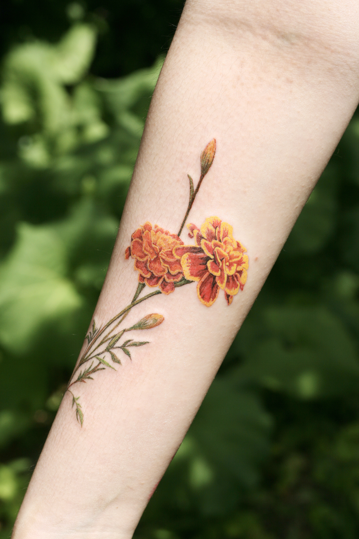 orange flower tattoo on arm