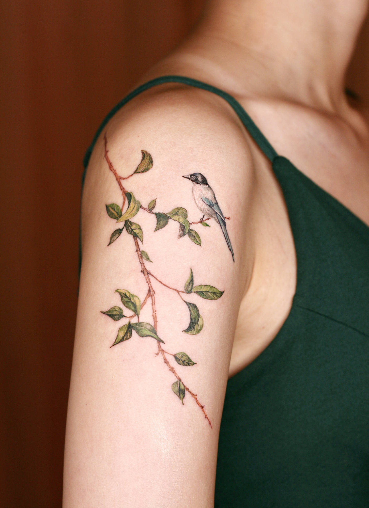 bird and leaf tattoo on shoulder