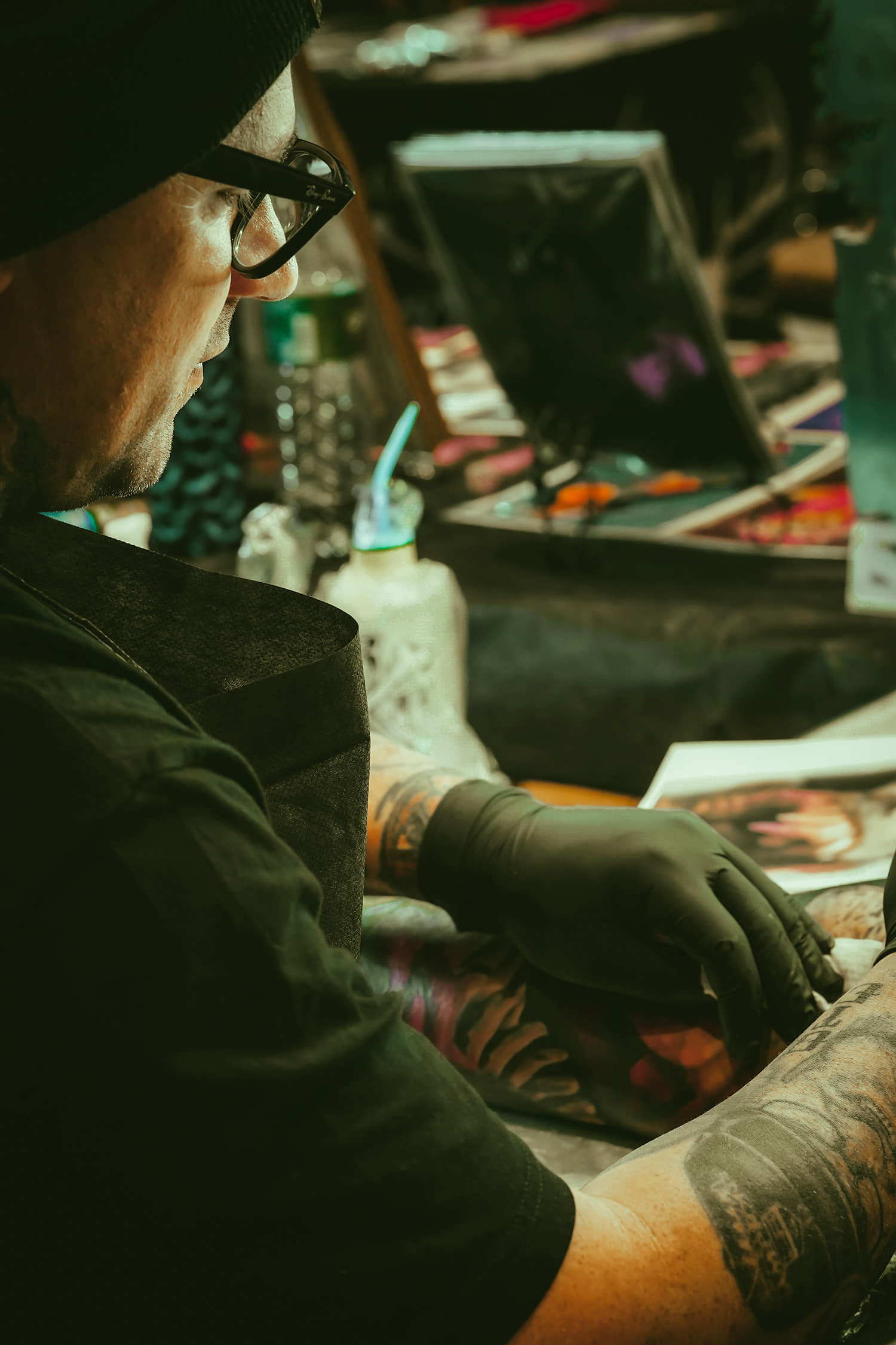 Tattooer Wade Titus doing an abstract and textural color arm sleeve photo copyright Adriana de Barros