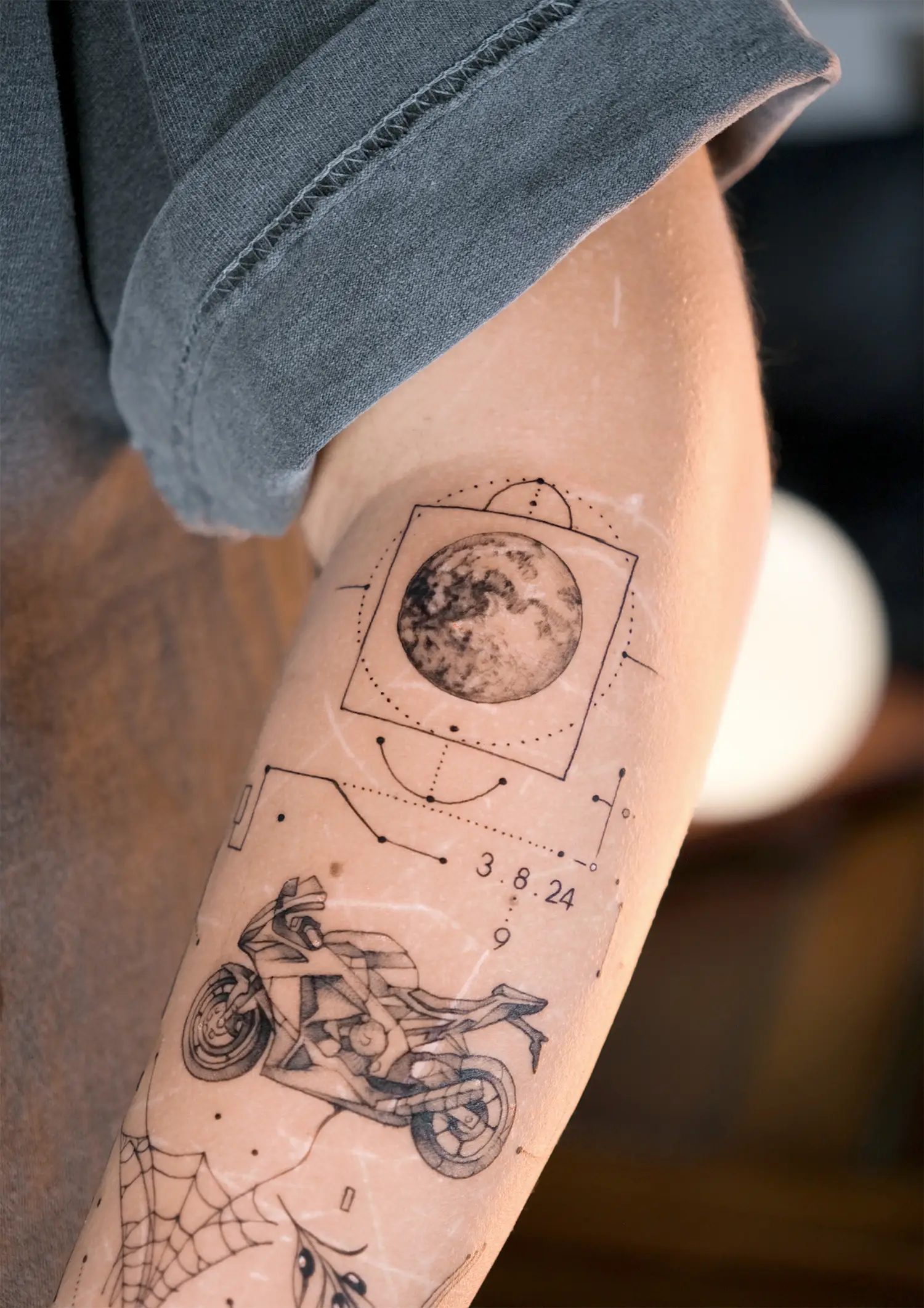 motocycle, a spiderweb and moon in meaningful tattoo composition