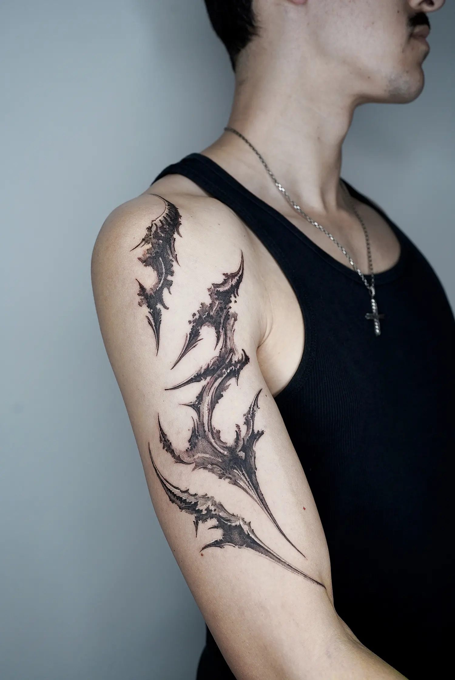 claw like abstract tattoo art on arm, black and white ink