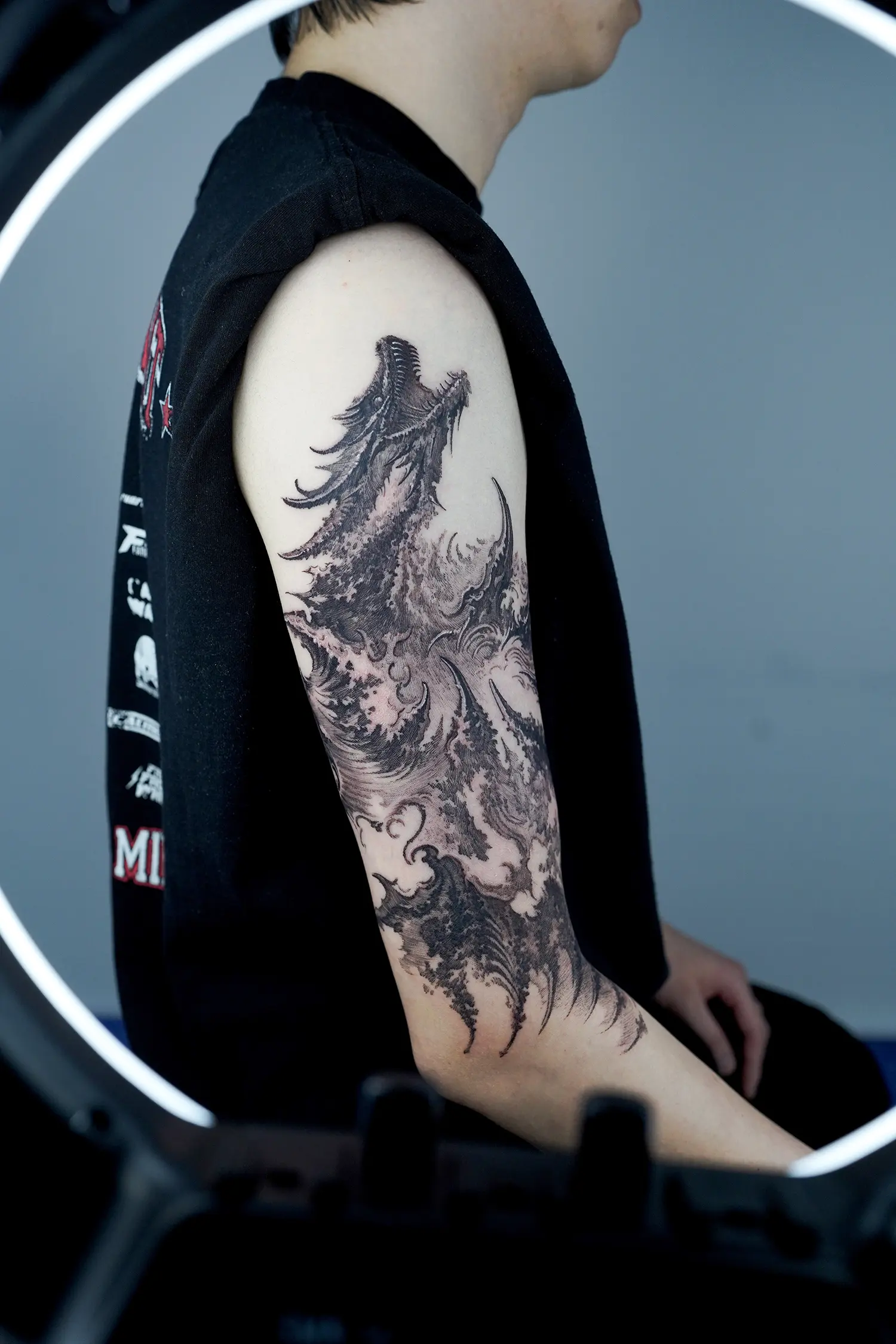Stylized dragon tattoo, looks like water and wind, black and white ink on arm