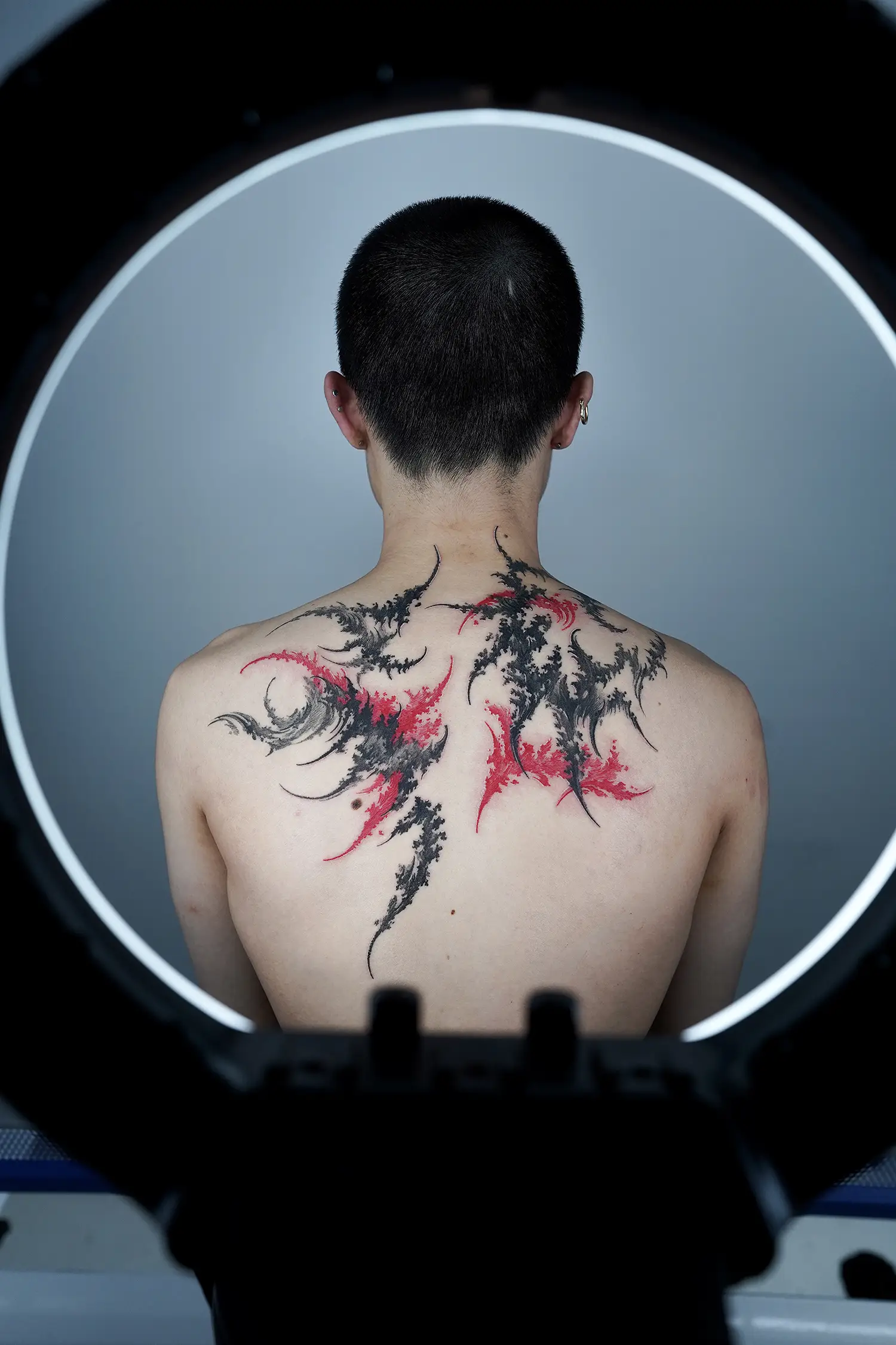 black and red abstract tattoo on back by solgrim