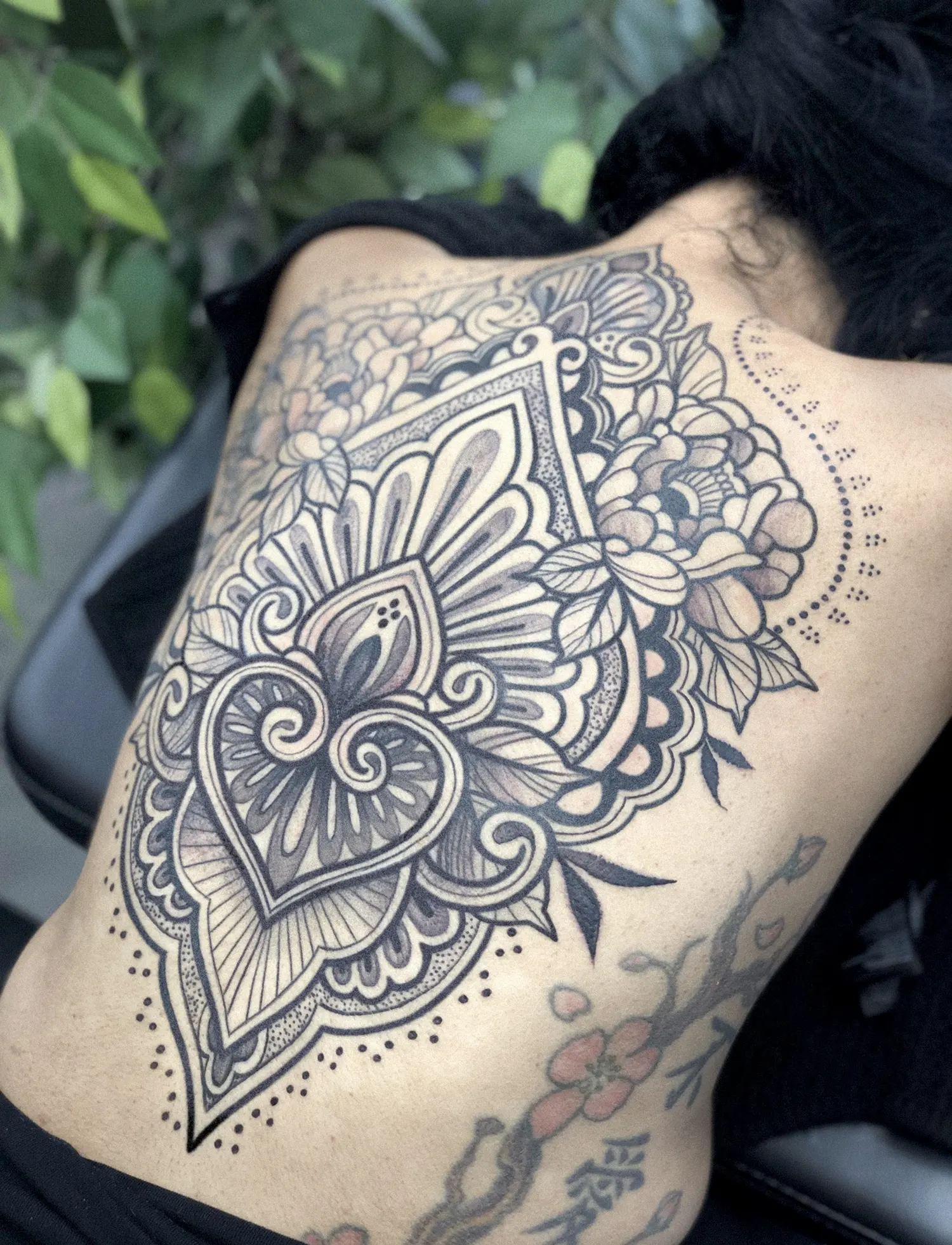 large ornamental back tattoo in black ink, a testament of the client strength