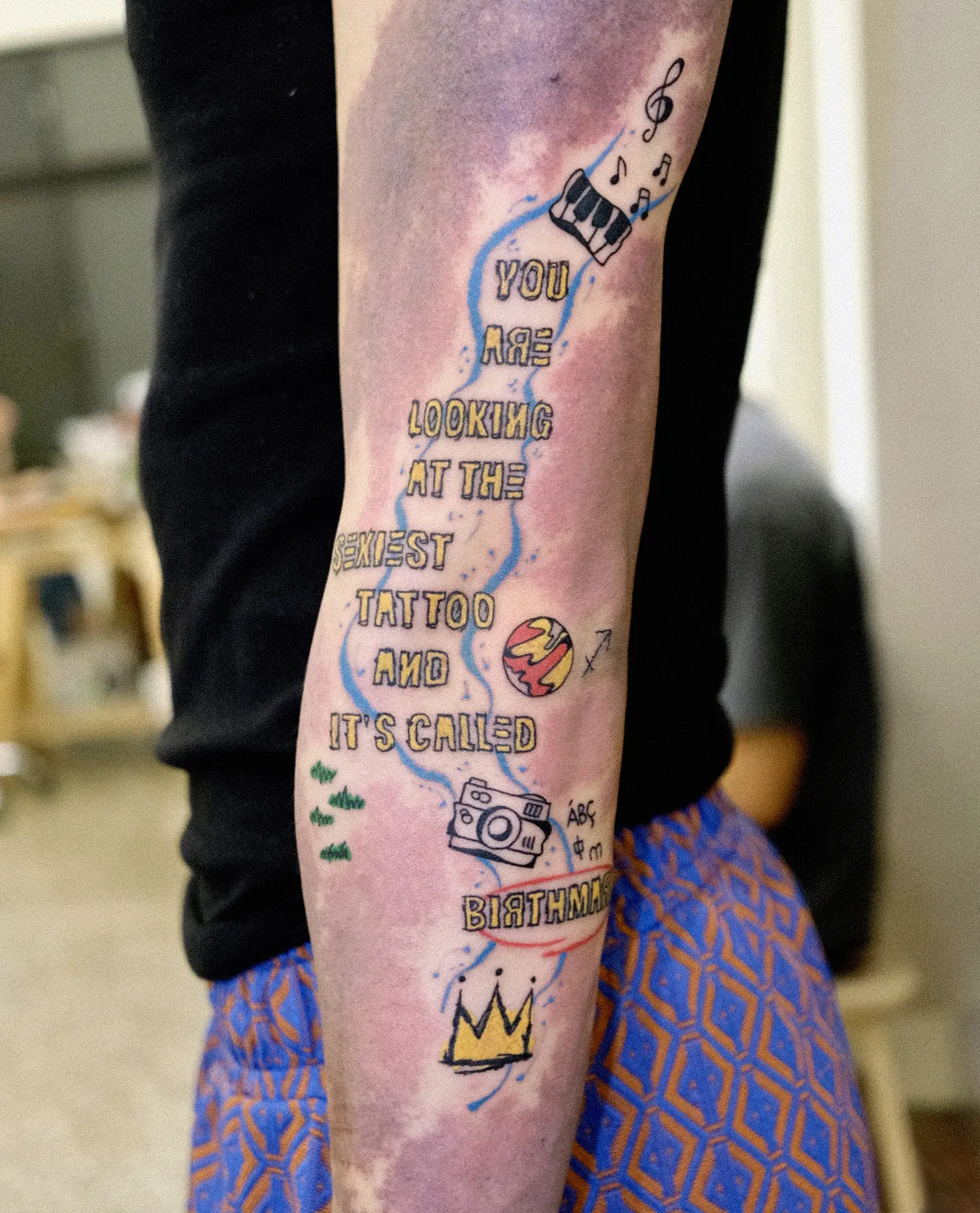 Making use of the purple birthmarks in the design of the tattoo, lettering tattoo