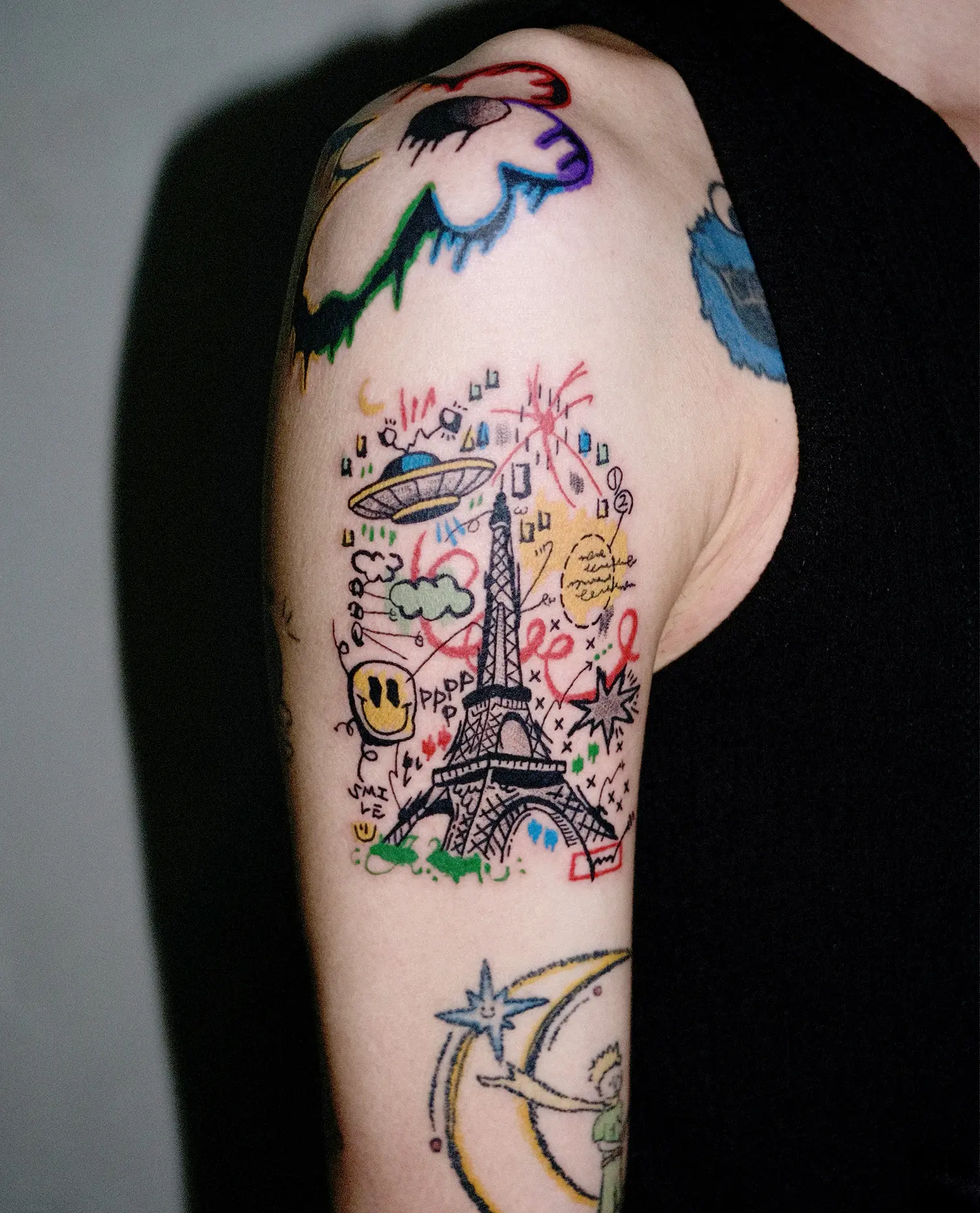 ufo spaceship and eiffel tower tattoo in sketch style on arm