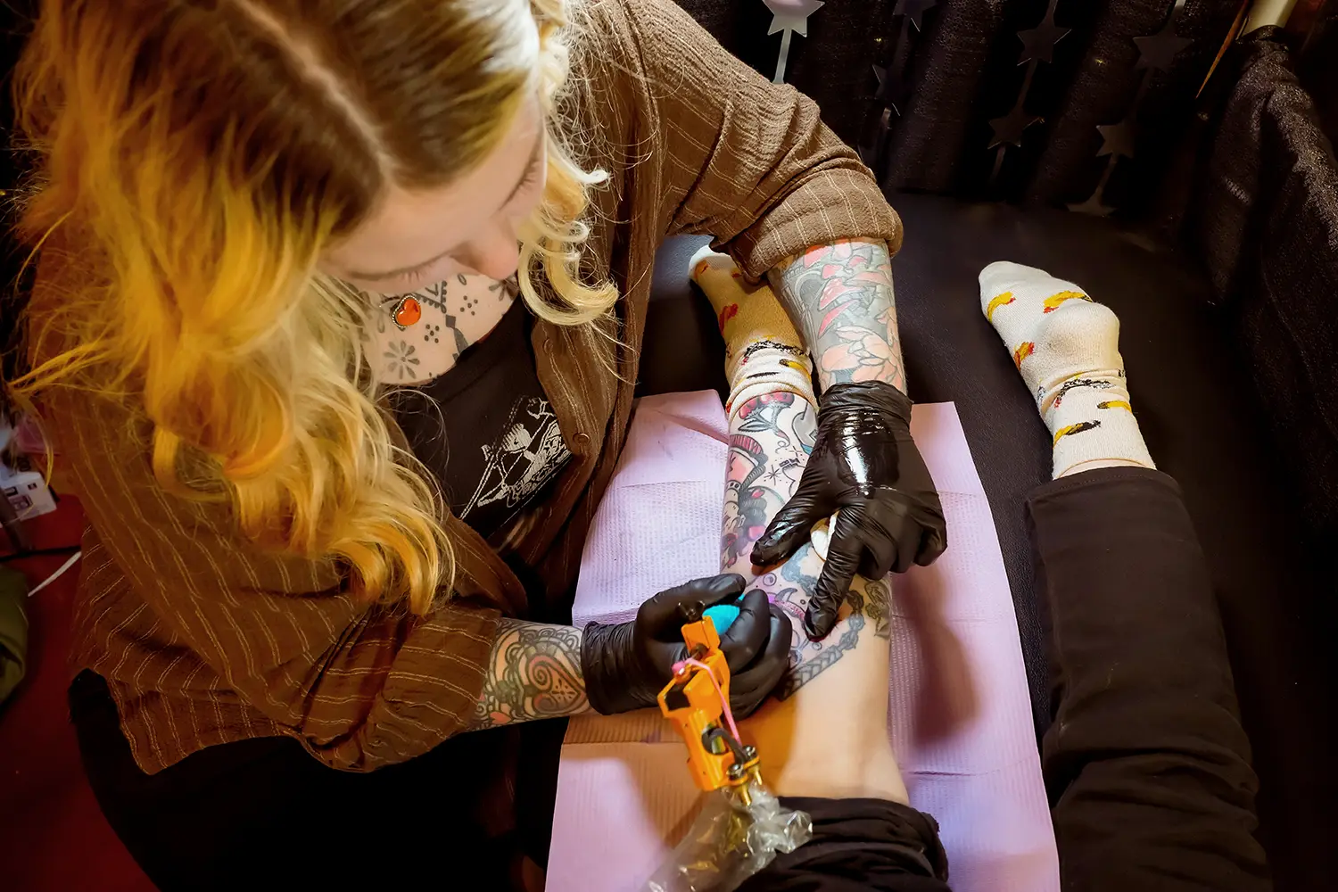 Lindsee Boyer, the proprietor of Bee Tattoo, a walk-in business in Minneapolis, is depicted in action