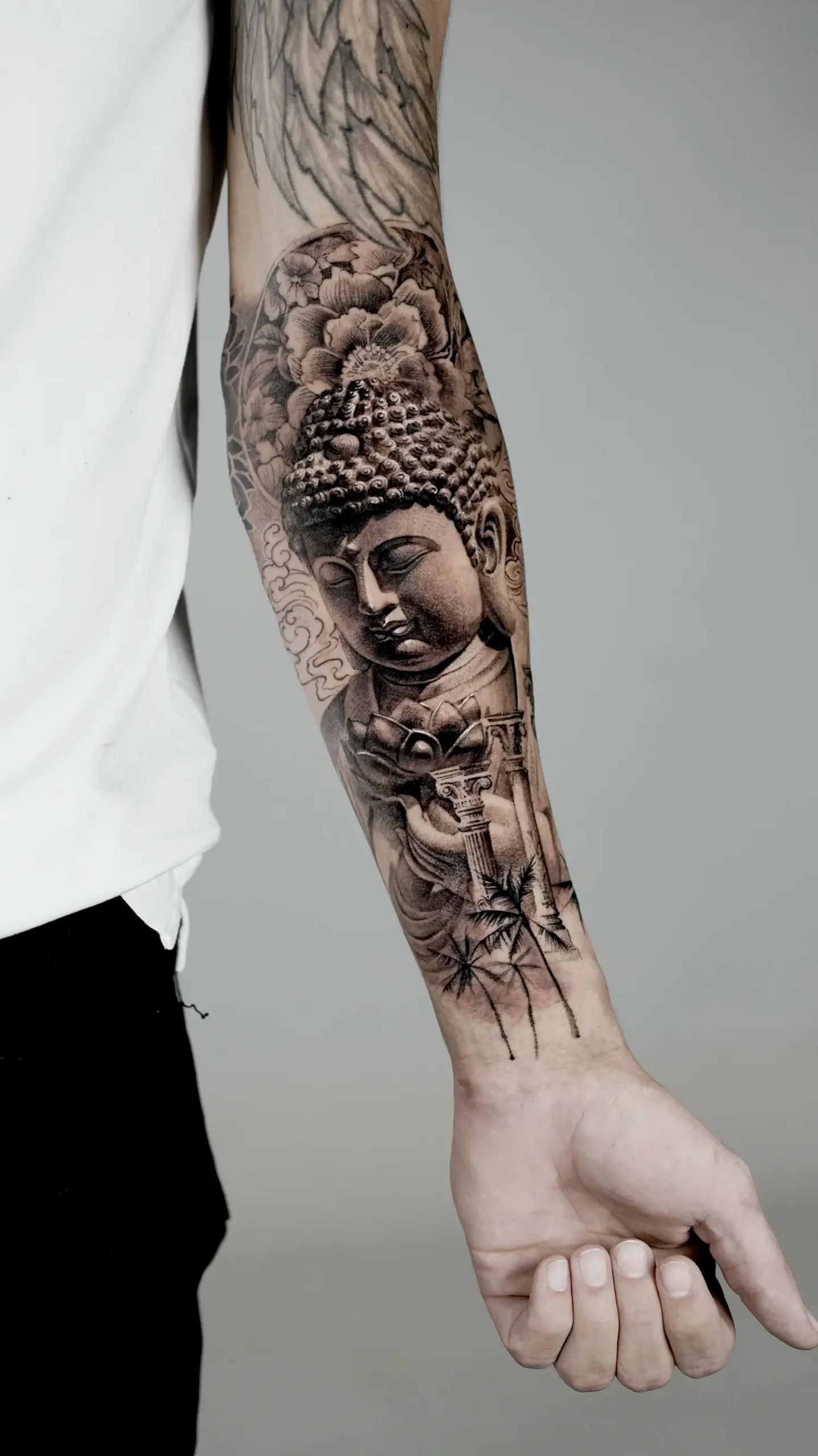 buddha sculpture tattoo on arm, in black and gray