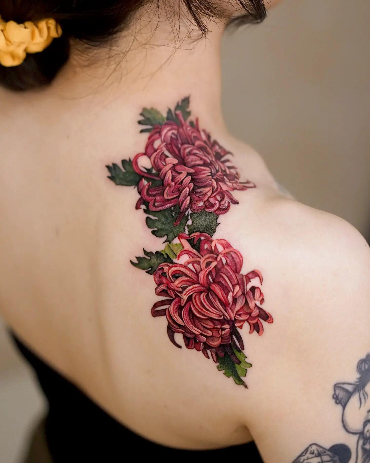 The chrysanthemum, with its exquisite detail, seems to jump off the skin and float in mid air.