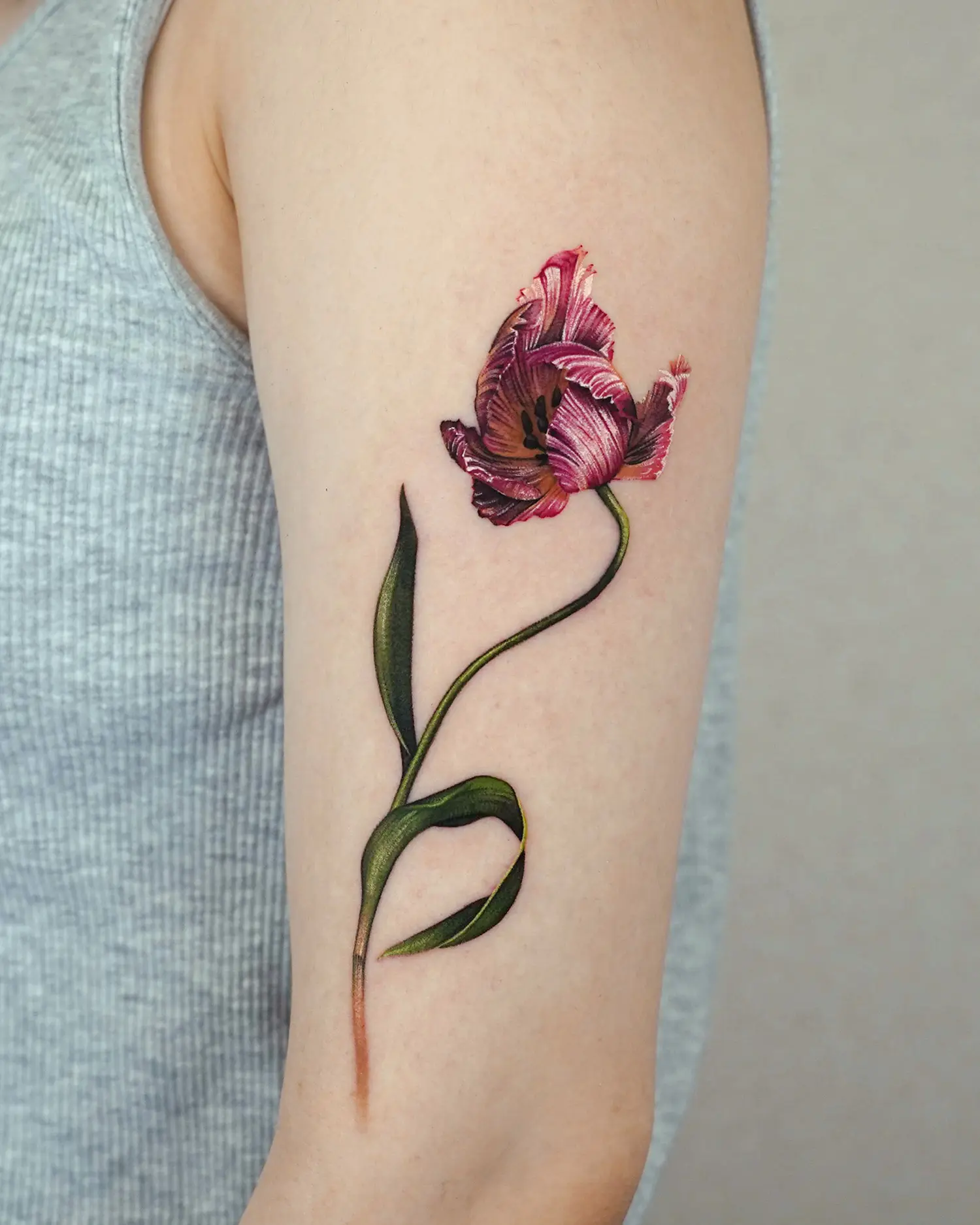 A single parrot tulip tattoo draws attention for its exotic, bird-like ruffled edges